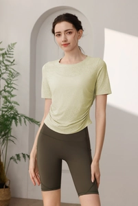 Détail du haut de yoga vert clair avec cordon latéral et short de sport vert olive