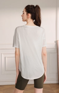 Détail du haut de yoga blanc en tencel avec ourlet arrondi et coupe ample respirante