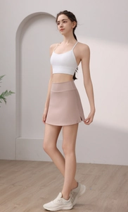 Detailansicht eines rosa Tennisrocks mit hoher Taille und weißem Sport-BH im modernen Studio