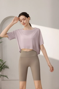 Detail of loose yoga top in lavender paired with high waisted cross waist yoga shorts