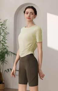 Détail du haut de sport vert avec cordon de serrage et poches sur le short de fitness