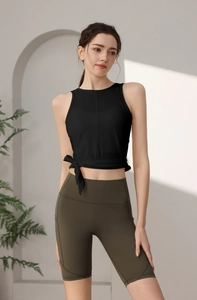 Detail eines schwarzen Yoga-Tops mit modischem Seitenknoten und olivgrüner Radlerhose