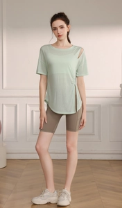 Détail du haut de yoga respirant vert clair avec découpe épaule et short gris