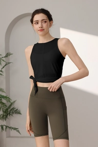 Nahaufnahme des schwarzen Yoga-Tops mit Seitenschleife und grüner Radlerhose