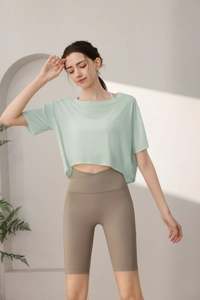 Detail of loose mint green Tencel crop top paired with high waist cross waist yoga shorts