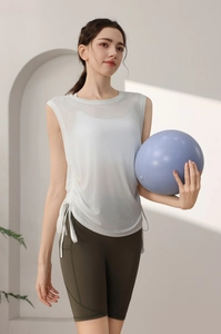 Detail view of white translucent tank top with side drawstrings and green cycling shorts