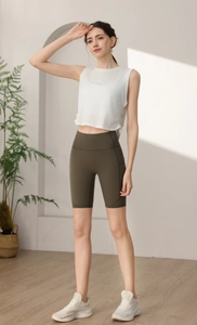 Dettaglio di maglietta sportiva senza maniche ampia e pantaloncini da yoga verde oliva