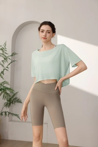 Detail of light green loose tencel sports top and khaki high-waisted fitness shorts set