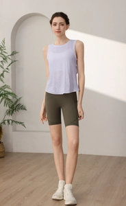 Dettaglio del gilet sportivo in rete viola chiaro e pantaloncini a vita alta verde oliva