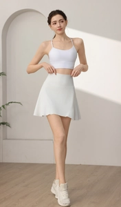 Dettaglio di una gonna sportiva a pieghe bianca e set reggiseno sportivo coordinato