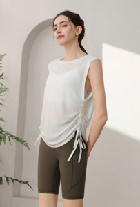Detail of loose yoga tank top with side drawstring and high-waist biker shorts