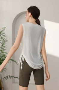 Close-up of light gray mesh sports tank top with side drawstring detail and olive shorts