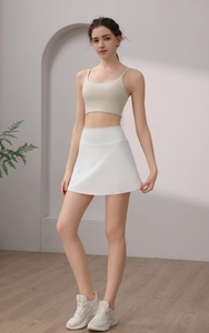 Detail eines weißen Sport-Faltenrocks mit hoher Taille und beige Sport-BH für Fitness