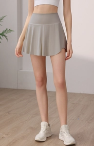 Détail de la taille haute et du design plissé de la jupe de sport en nylon pour femmes gris