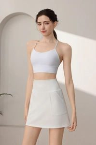Dettaglio di gonna da tennis bianca con tasche e reggiseno sportivo con spalline incrociate
