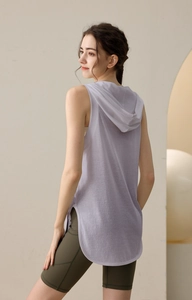 Detail view of lavender hooded sports vest with curved hem and olive yoga shorts
