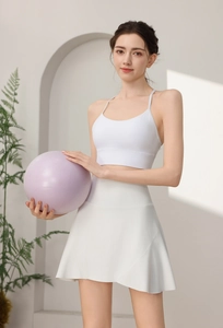 Vista dettagliata della gonna da tennis bianca a vita alta e reggiseno sportivo su modella
