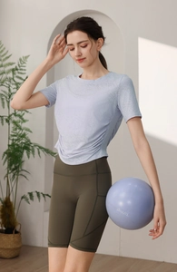 Détail du haut de yoga violet cintré avec cordon latéral et short vert taille haute