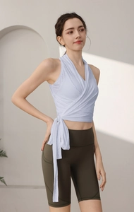 Dettaglio del top da yoga blu con laccio laterale e pantaloncini da ciclista con tasche