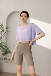 Detail of loose fit light purple yoga crop top and khaki cycling shorts with side pocket