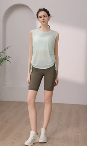Detail view of quick-dry yoga top with side drawstrings and olive green cycling shorts