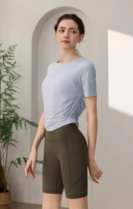 Détail du haut de yoga violet clair avec cordon de serrage et short de cyclisme vert