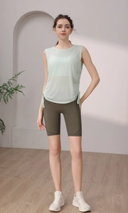 Detail of mint green sleeveless sports vest with side drawstring and olive green shorts