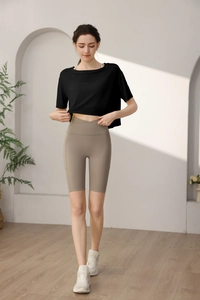 Detail of high-waist yoga shorts with cross waistband and side pockets in khaki color