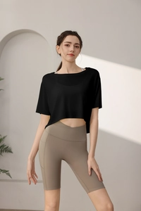 Detail view of loose crop-top fitness shirt and high-waist yoga shorts with pockets
