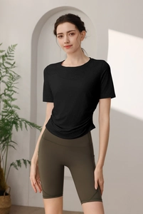 Détail du haut de sport en nylon noir et du short de cyclisme vert taille haute pour femme