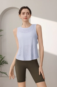 Dettaglio della canotta da yoga lilla traspirante e pantaloncini fitness verdi a vita alta