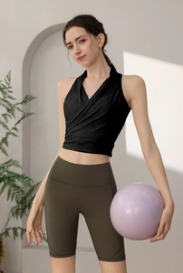 Dettaglio del set top fitness nero incrociato e pantaloncini da yoga verde oliva