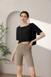 Detail of high-waisted khaki yoga shorts with V-shaped waistband and black crop top