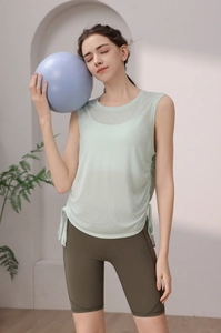 Detail of light green yoga tank top with side drawstring design and olive cycling shorts
