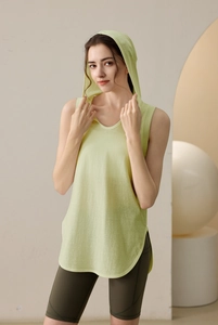 Detail view of the light green hooded vest with side slits and olive green cycling shorts