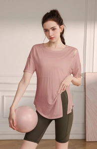 Détail du haut de yoga rose avec fente latérale et découpe élégante à l'épaule