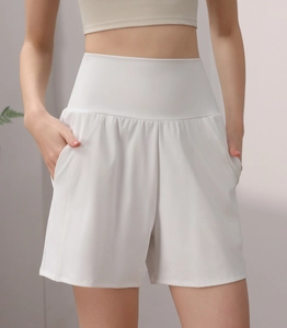 Detailed close-up of white high-waisted yoga shorts with side pockets and wide waistband