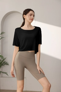 Detail of loose black cropped fitness top with brown high-waisted cycling shorts
