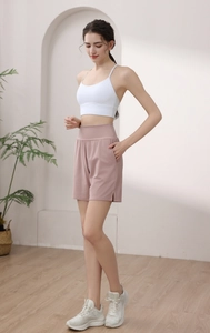 Detail of high-waisted pink sports shorts with side pockets and split hem for running