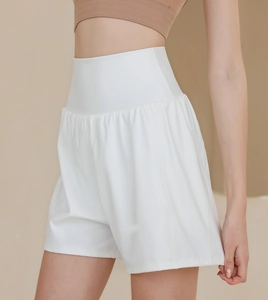 Détail du short de yoga blanc à taille haute montrant la ceinture large et la coupe ample
