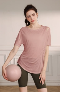 Détail du haut de yoga rose avec découpe à l'épaule et plis latéraux à cordon coulissant
