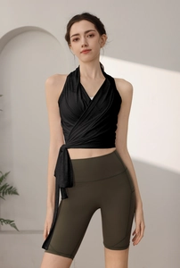 Dettaglio del top da yoga slim fit con design a incrocio e tessuto dei pantaloncini da ciclista