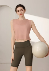 Dettaglio top yoga rosa senza maniche con pantaloncini da ciclista a vita alta oliva