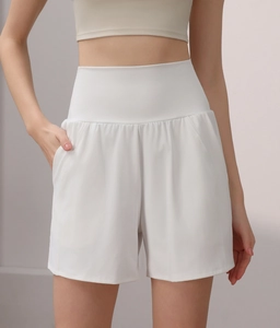 Detail of high-waisted white nylon yoga shorts showing side pockets and wide waistband