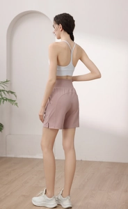 Vue détaillée du short de sport rose à taille haute et de la brassière de yoga blanche sport