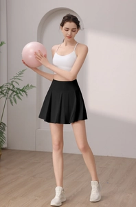 Detail eines schwarzen Tennisrocks mit hoher Taille, Falten und weißem Sport-BH am Model