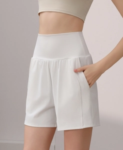 Close-up of high-waisted white nylon yoga shorts with functional side pockets on model