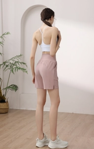 Side view of pink high-waisted nylon sports shorts with side slits for running and yoga