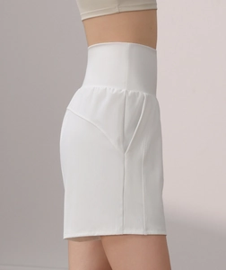 Detail of high waisted white yoga shorts featuring wide waistband and side pockets