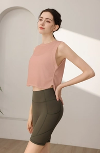 Dettaglio della canotta sportiva rosa senza maniche e pantaloncini da yoga verdi a vita alta
